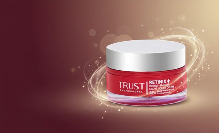 عکس بنر کرم رتینول تراست قرمز رنگ با درب سفید، همراه با جلوه‌های نوری طلایی و ذرات درخشان در زمینه قهوه‌ای تیره.